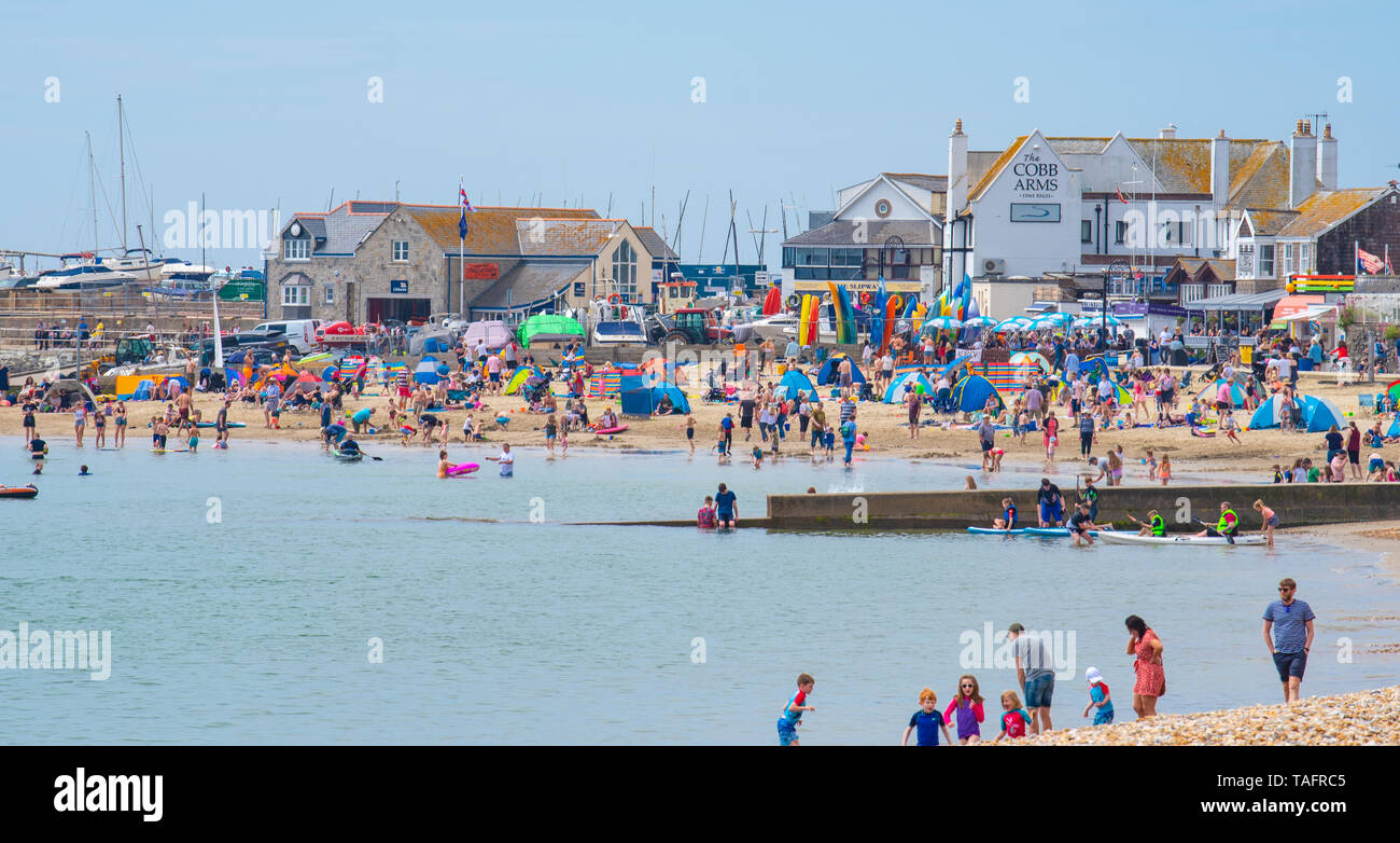 Lyme Regis, Dorset, Regno Unito. 25 maggio 2019. Meteo REGNO UNITO: folle di turisti e visitatori accorrono per la spiaggia di Lyme Regis a crogiolarvi al sole caldo come il resort costiero sfrigola su il giorno più caldo dell'anno finora. Il sabato è impostata in modo da essere il più soleggiato giorno di fine maggio weekend festivo. Credito: Celia McMahon/Alamy Live News. Credito: Celia McMahon/Alamy Live News Foto Stock