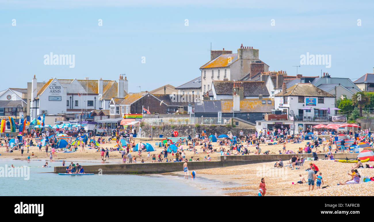 Lyme Regis, Dorset, Regno Unito. 25 maggio 2019. Meteo REGNO UNITO: folle di turisti e visitatori accorrono per la spiaggia di Lyme Regis a crogiolarvi al sole caldo come il resort costiero sfrigola su il giorno più caldo dell'anno finora. Il sabato è impostata in modo da essere il più soleggiato giorno di fine maggio weekend festivo. Credito: Celia McMahon/Alamy Live News. Credito: Celia McMahon/Alamy Live News Foto Stock