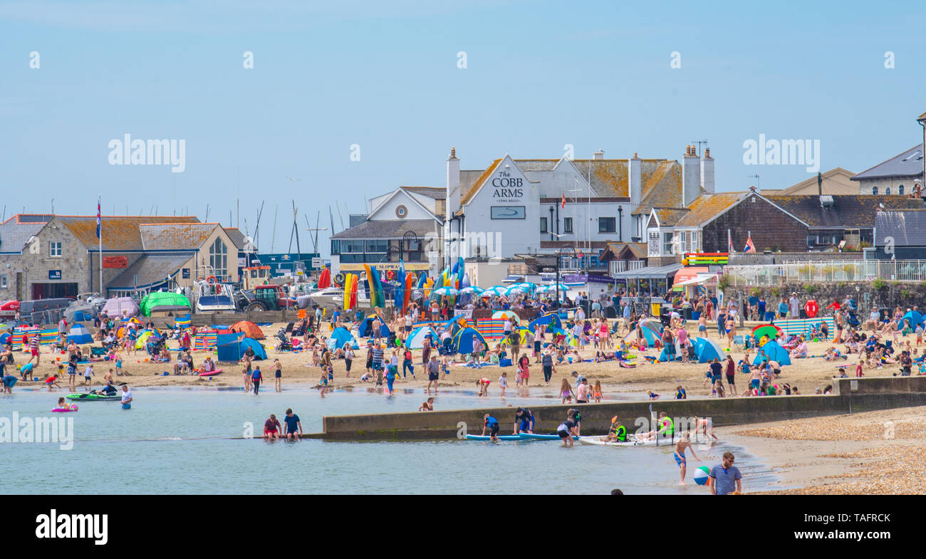 Lyme Regis, Dorset, Regno Unito. 25 maggio 2019. Meteo REGNO UNITO: folle di turisti e visitatori accorrono per la spiaggia di Lyme Regis a crogiolarvi al sole caldo come il resort costiero sfrigola su il giorno più caldo dell'anno finora. Il sabato è impostata in modo da essere il più soleggiato giorno di fine maggio weekend festivo. Credito: Celia McMahon/Alamy Live News. Credito: Celia McMahon/Alamy Live News Foto Stock