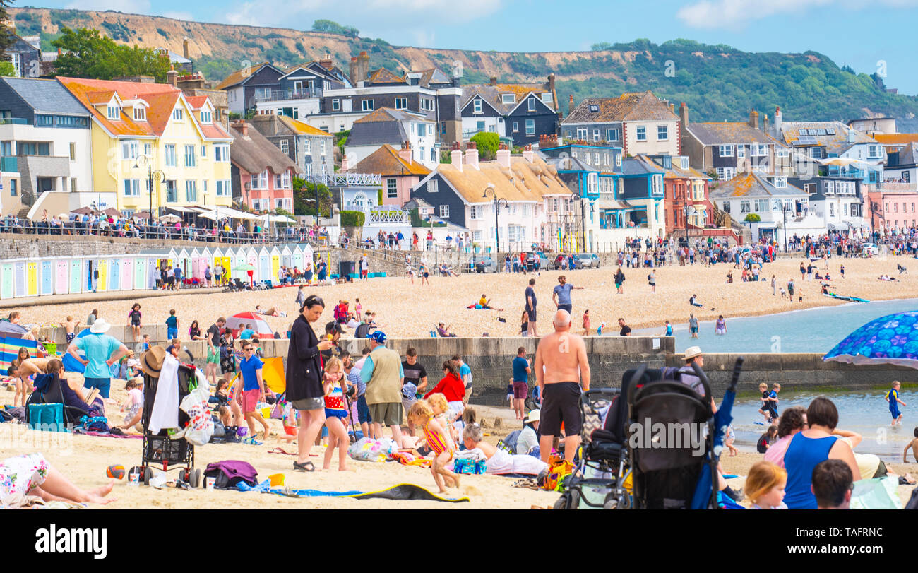 Lyme Regis, Dorset, Regno Unito. 25 maggio 2019. Meteo REGNO UNITO: folle di turisti e visitatori accorrono per la spiaggia di Lyme Regis a crogiolarvi al sole caldo come il resort costiero sfrigola su il giorno più caldo dell'anno finora. Il sabato è impostata in modo da essere il più soleggiato giorno di fine maggio weekend festivo. Credito: Celia McMahon/Alamy Live News. Credito: Celia McMahon/Alamy Live News Foto Stock