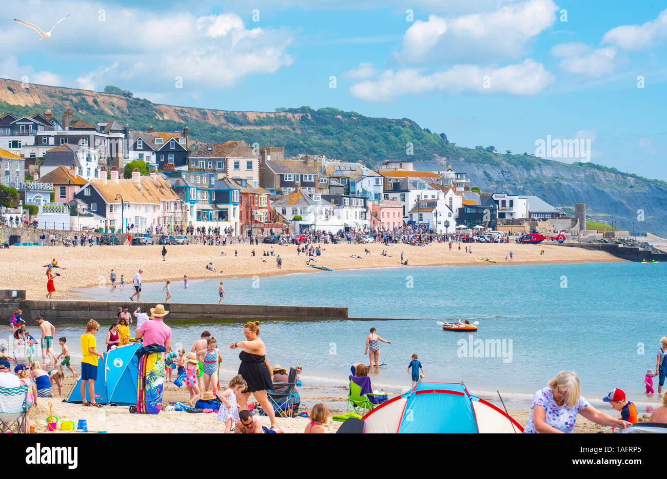Lyme Regis, Dorset, Regno Unito. 25 maggio 2019. Meteo REGNO UNITO: folle di turisti e visitatori accorrono per la spiaggia di Lyme Regis a crogiolarvi al sole caldo come il resort costiero sfrigola su il giorno più caldo dell'anno finora. Il sabato è impostata in modo da essere il più soleggiato giorno di fine maggio weekend festivo. Credito: Celia McMahon/Alamy Live News. Credito: Celia McMahon/Alamy Live News Foto Stock