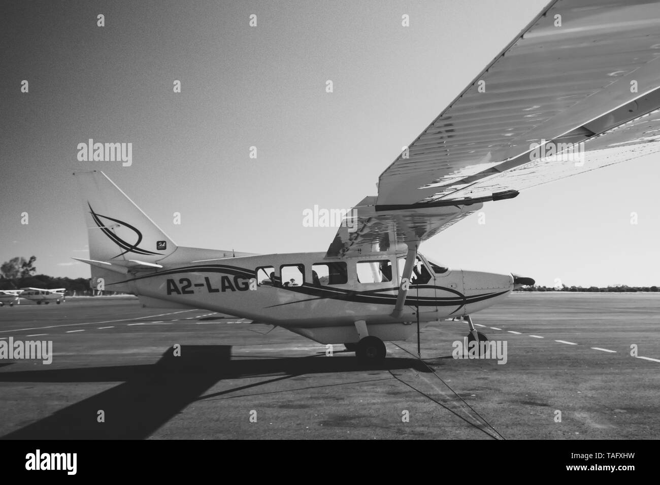 Maun, Botswana, Ottobre 2014: aerei Cessna parcheggiato permanente presso la pista di atterraggio dell'aeroporto locale durante il sunrise Foto Stock