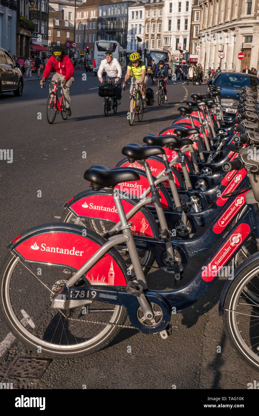 TFL Santander sponsorizzato London red noleggio noleggio bici a Southwark Street. Un gruppo di ciclisti di " commuters " indossare i caschi in sella da bicicletta terminal stazione docking. Trasporto per London Southwark London REGNO UNITO Foto Stock