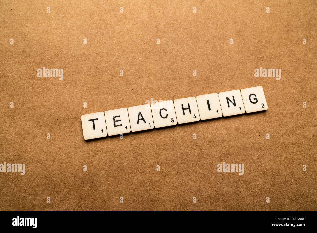 LONDON, Regno Unito - 24 Maggio 2019: La parola insegnamento, farro con lettera in legno piastrelle su un marrone sfondo testurizzata Foto Stock