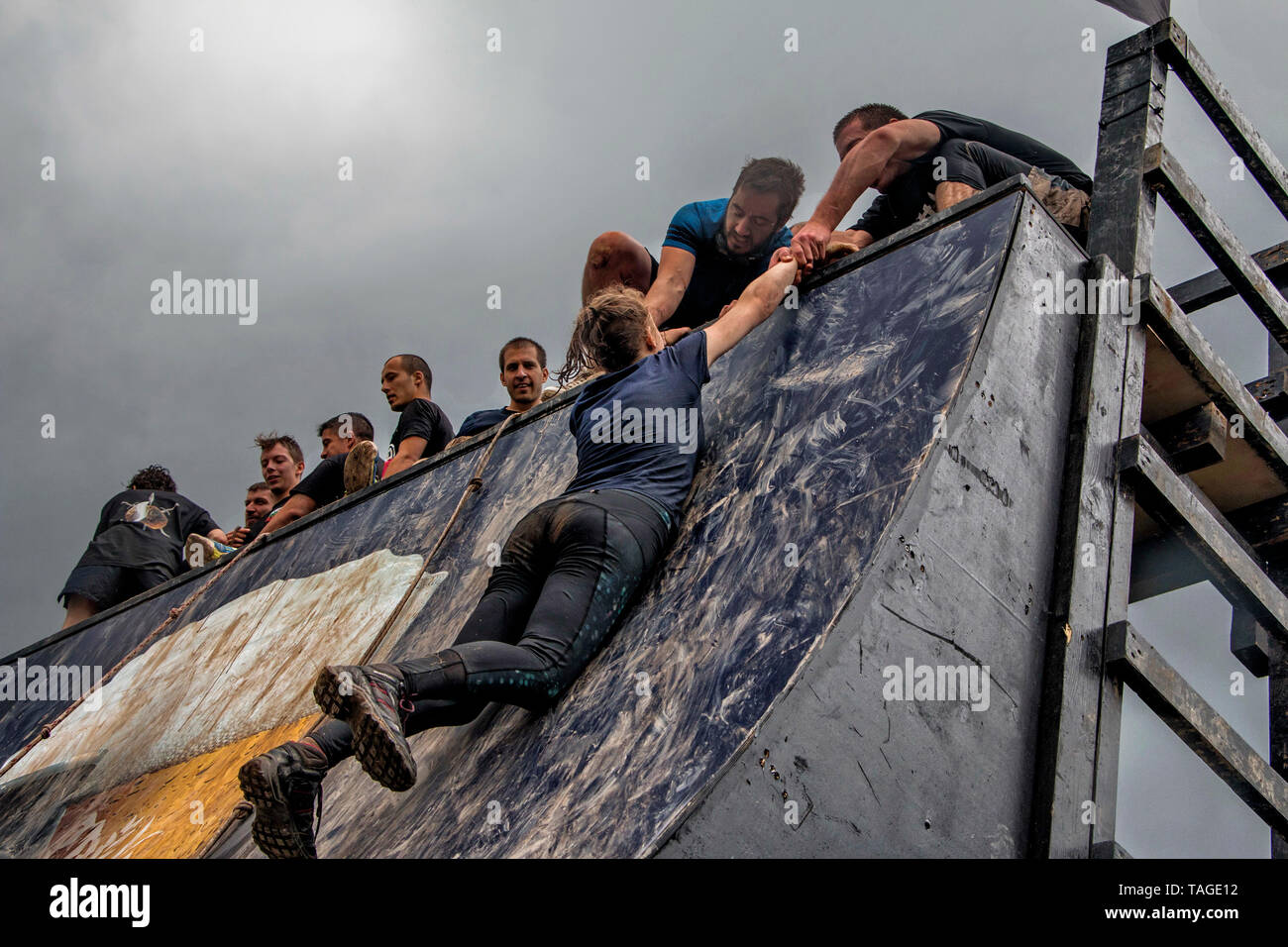 SOFIA, BULGARIA - 7 luglio 2018 - i partecipanti stanno contribuendo a una donna di superare un ostacolo parete in una gara di resistenza Foto Stock