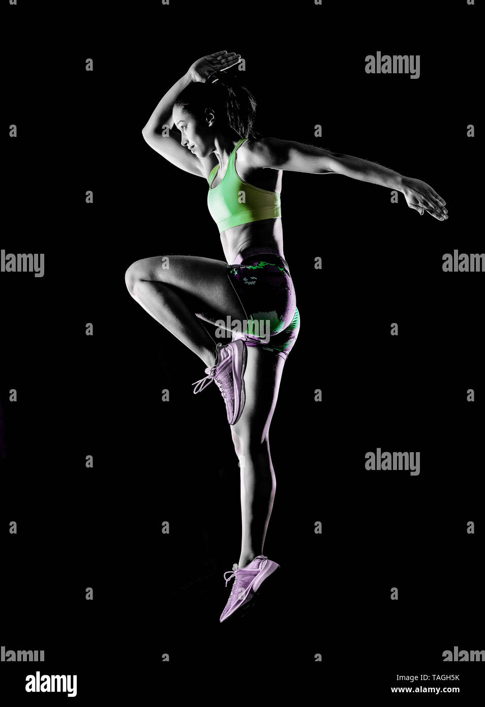 Una razza mista donna esercizio esercizi fitness isolati su sfondo nero con effetto lightpainting Foto Stock