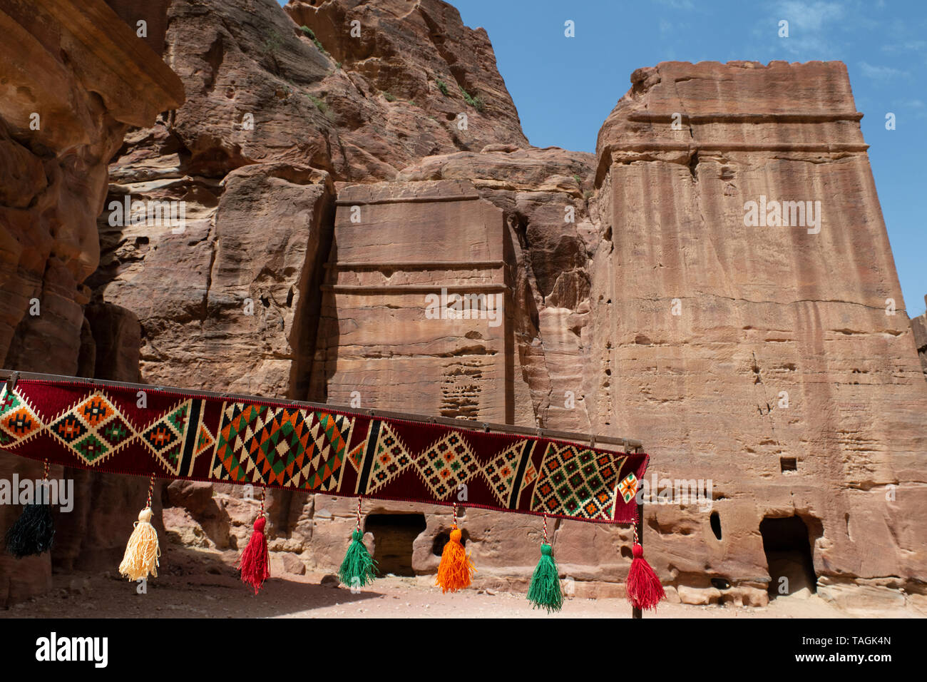 Giordania Petra (UNESCO) la strada delle facciate. Tipici prodotti tessili Giordano nella parte anteriore delle tombe in pietra. Foto Stock