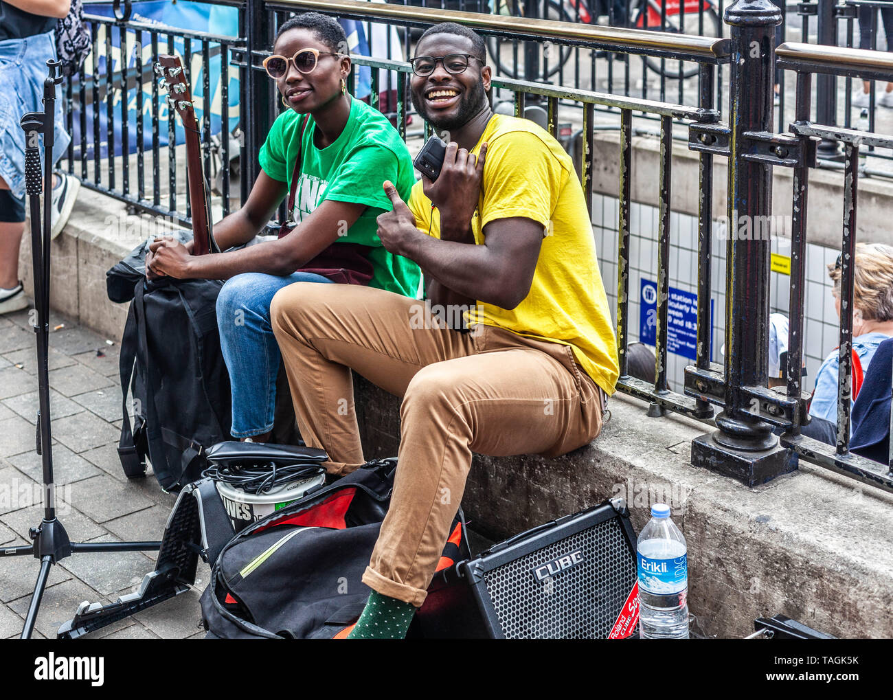 Ritratto di due sorridente buskers su una pausa, Londra, Inghilterra, Regno Unito. Foto Stock