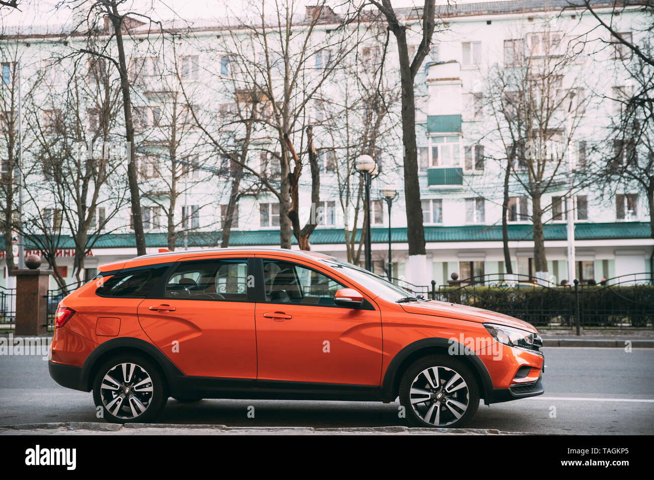 Gomel, Bielorussia - Aprile 8, 2019: Orange Lada Vesta Croce SW auto parcheggiate lungo la strada. Vista laterale Foto Stock