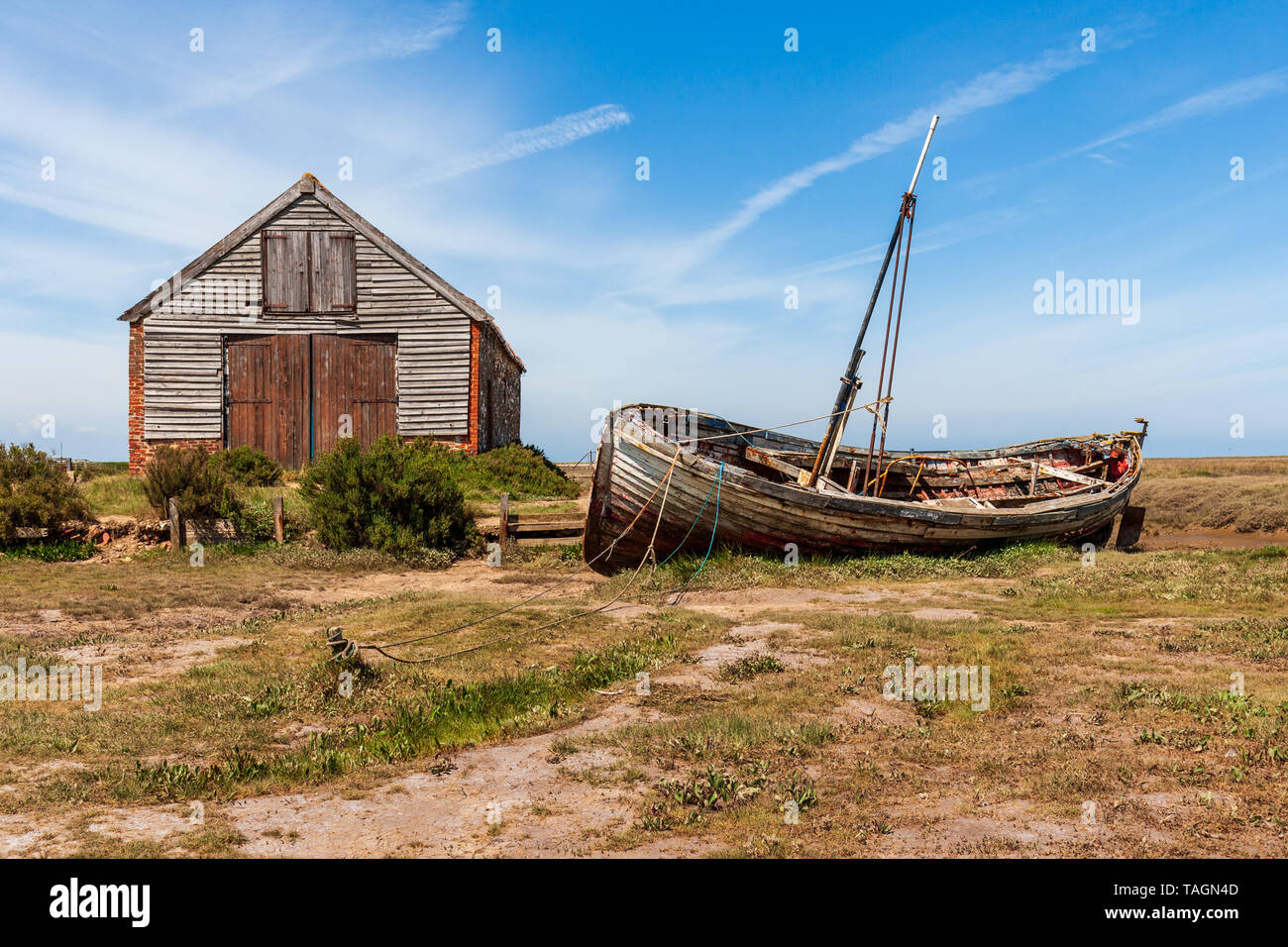 Vista del vecchio capannone di carbone e la vecchia barca di legno a thornham porto sulla Costa North Norfolk Foto Stock