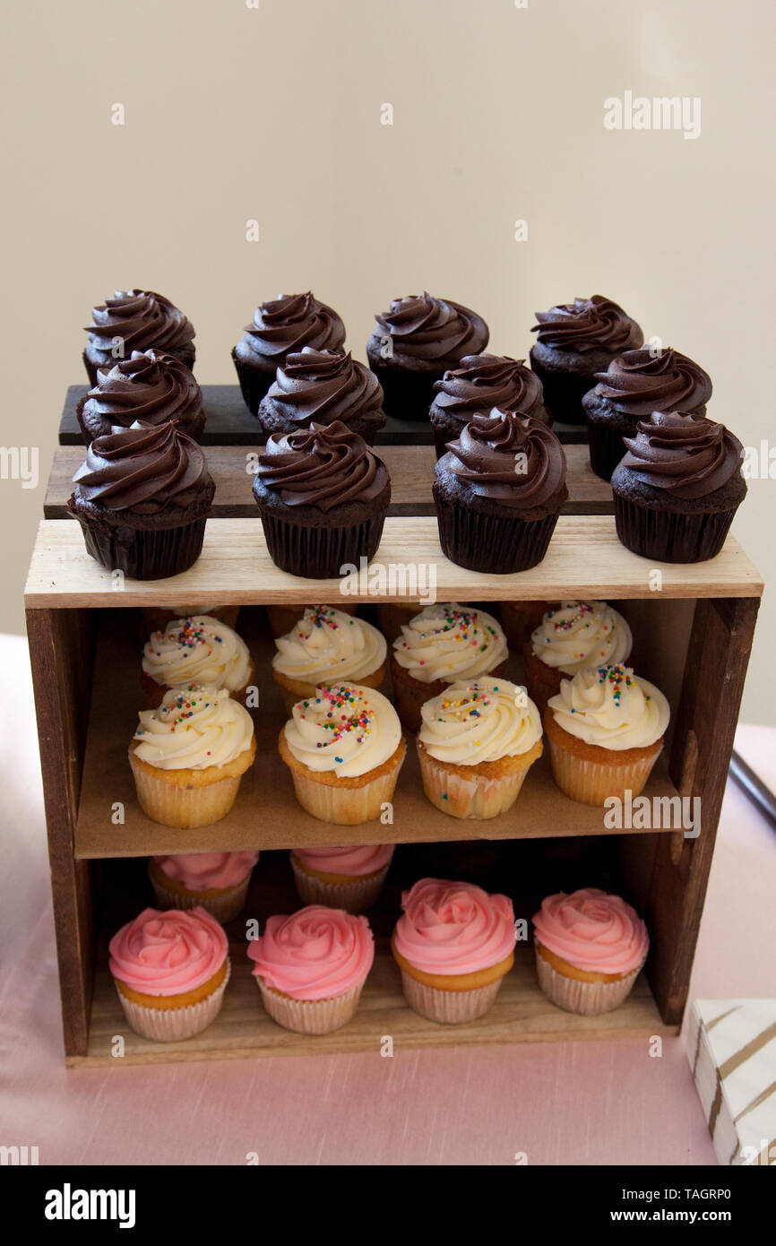 Cioccolato, fragola e vaniglia tortine su un tavolo in legno display Foto Stock