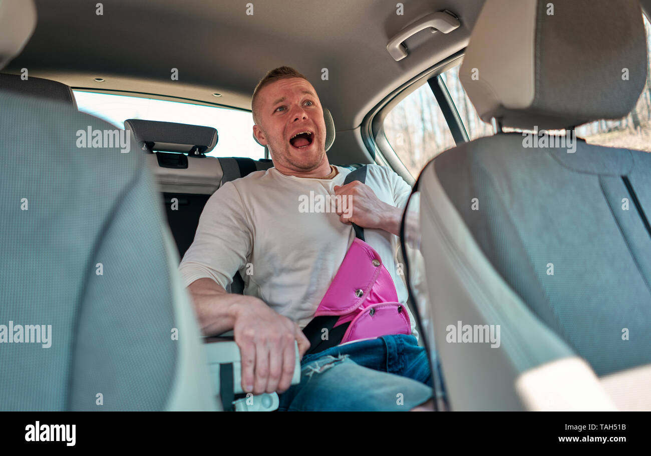 Adulto Uomo indossare bambino cintura di sicurezza in auto nel sedile posteriore Foto Stock