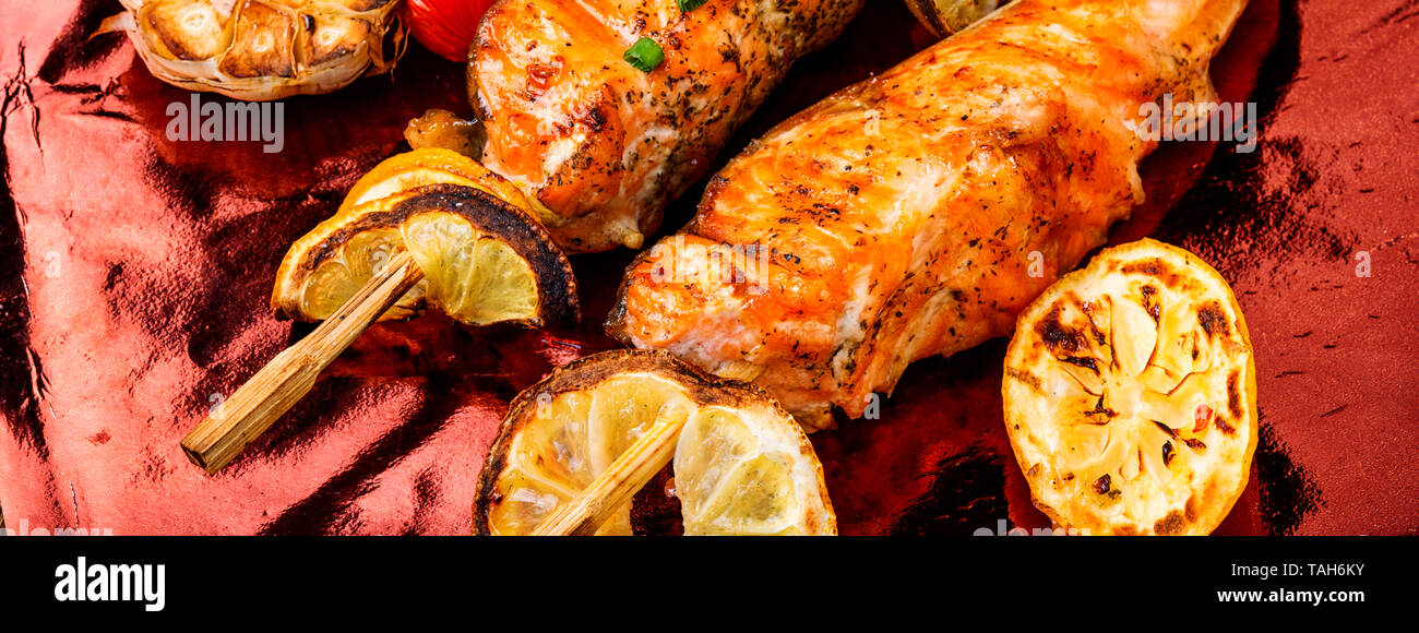 Grigliate di pesce alla griglia bistecca di salmone con aggiunta di succo di limone Foto Stock