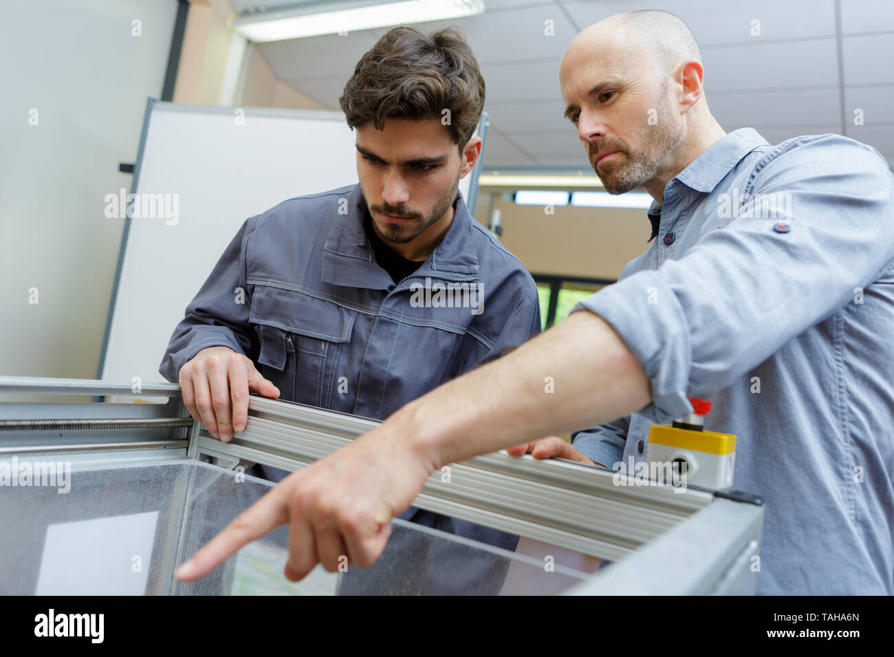 Due operai attento lavoro in pvc di fabbrica di windows Foto Stock