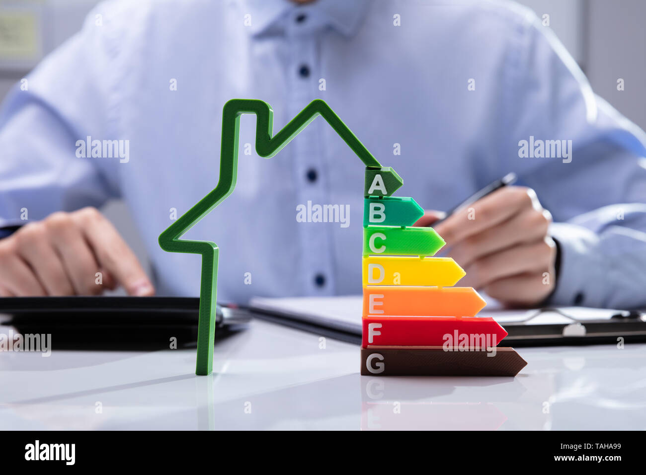Casa con efficienza energetica tasso di fronte imprenditori lavora su documenti Foto Stock