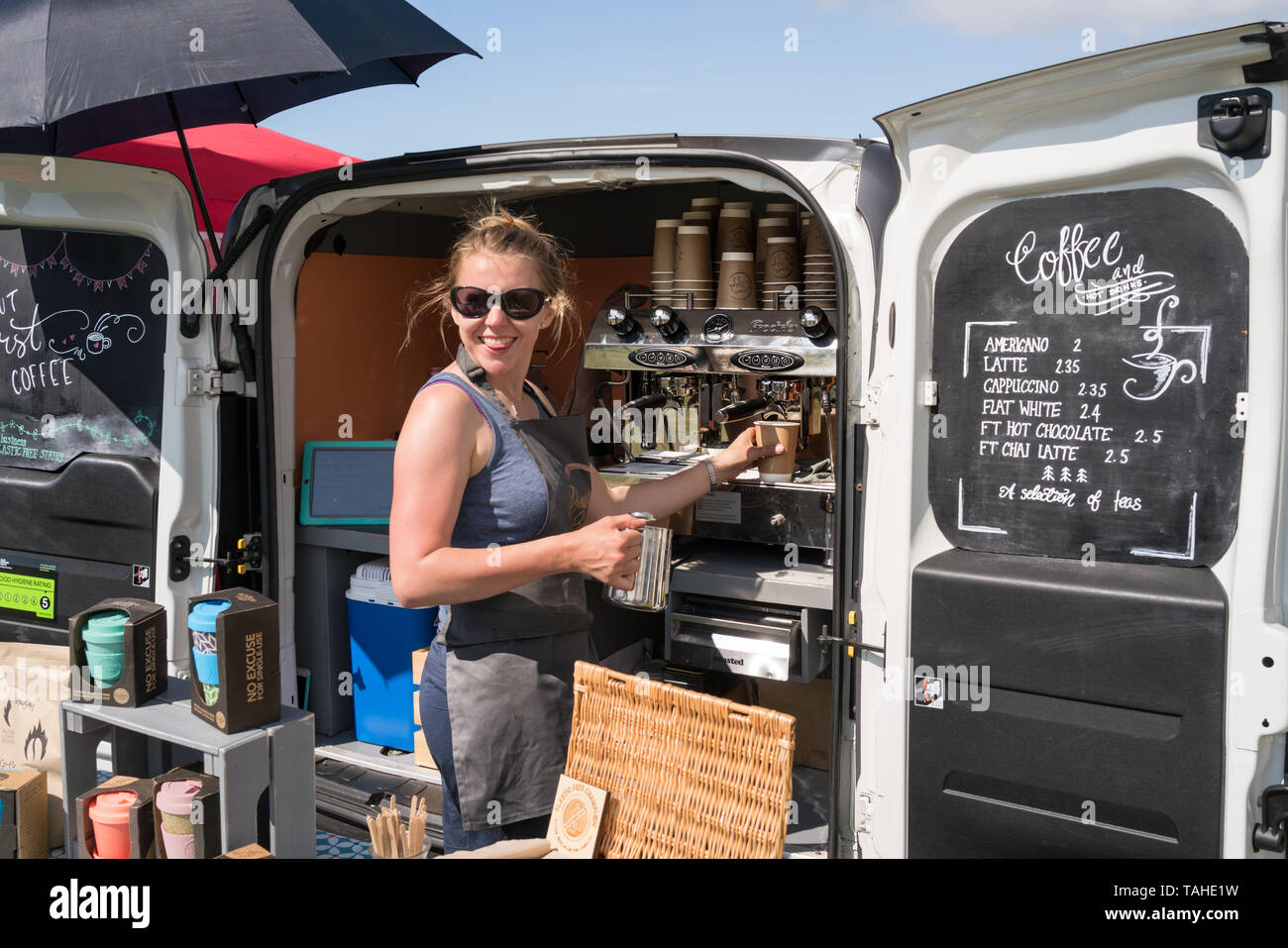 Sorridenti caffè proprietario di stallo a Mudeford festival di frutti di mare sulla banchina del porto con sfondo Foto Stock