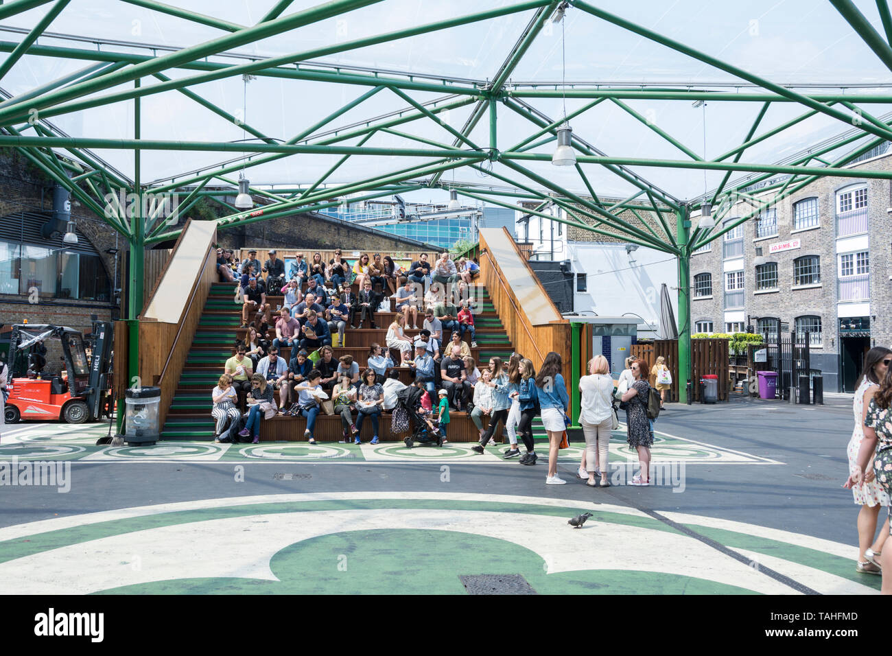 Persone in appoggio e mangiare i loro spuntini accanto al Mercato di Borough, London, SE1, Regno Unito Foto Stock