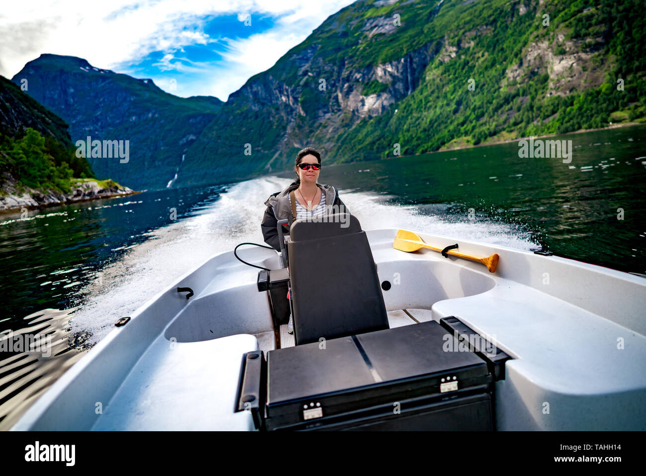 Donna alla guida di una barca a motore. Geiranger fjord, la bellissima natura della Norvegia.La vacanza estiva. Geiranger Fjord, un sito Patrimonio Mondiale dell'UNESCO. Foto Stock