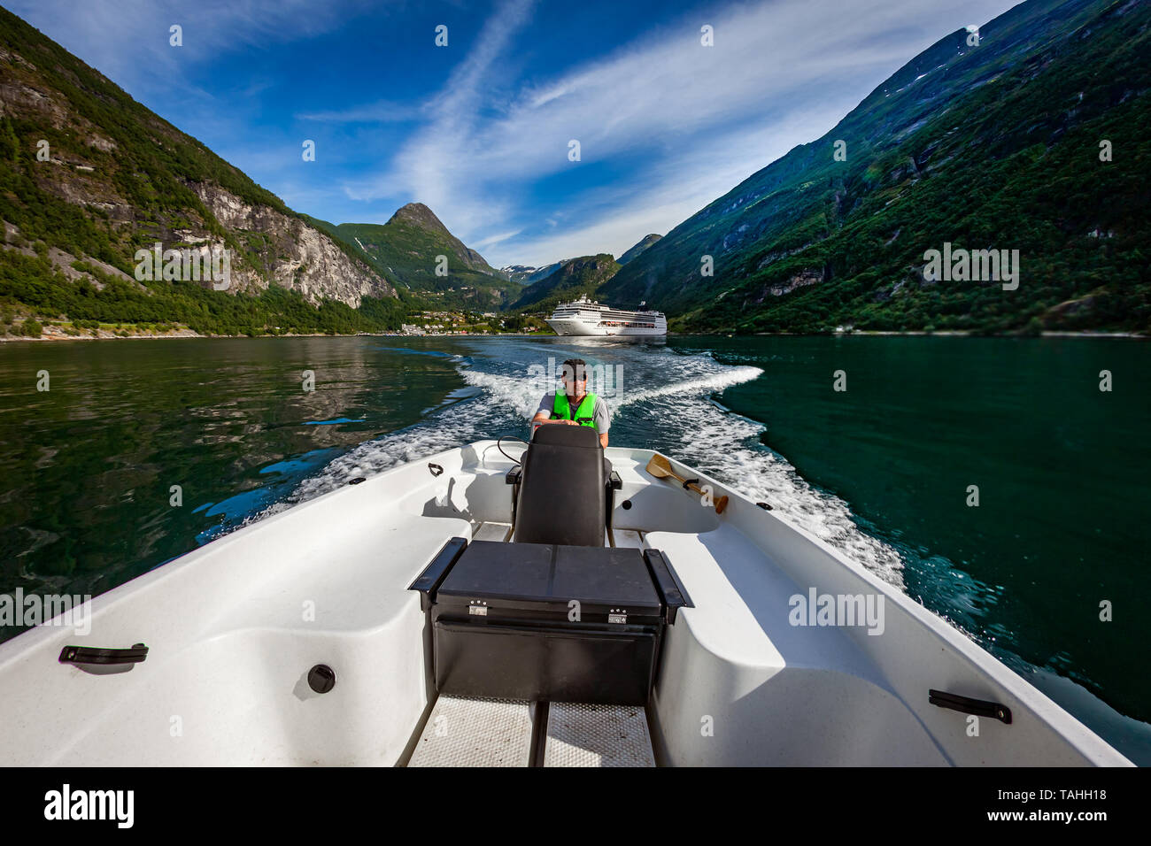 Uomo alla guida di una barca a motore. Geiranger fjord, la bellissima natura della Norvegia.La vacanza estiva. Geiranger Fjord, un sito Patrimonio Mondiale dell'UNESCO. Foto Stock