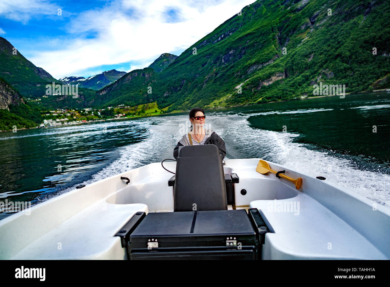 Donna alla guida di una barca a motore. Geiranger fjord, la bellissima natura della Norvegia.La vacanza estiva. Geiranger Fjord, un sito Patrimonio Mondiale dell'UNESCO. Foto Stock