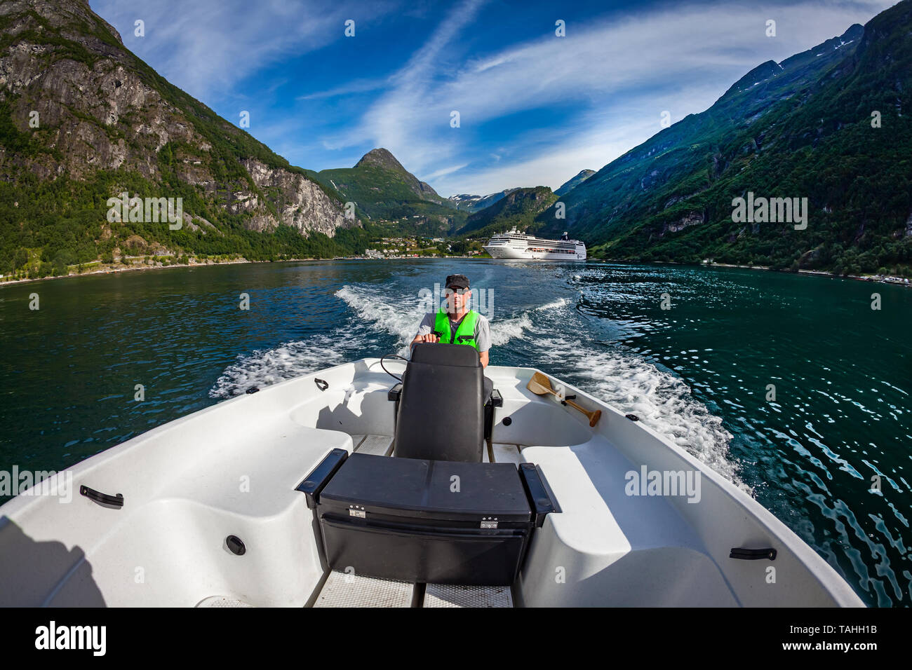 Uomo alla guida di una barca a motore. Geiranger fjord, la bellissima natura della Norvegia.La vacanza estiva. Geiranger Fjord, un sito Patrimonio Mondiale dell'UNESCO. Foto Stock