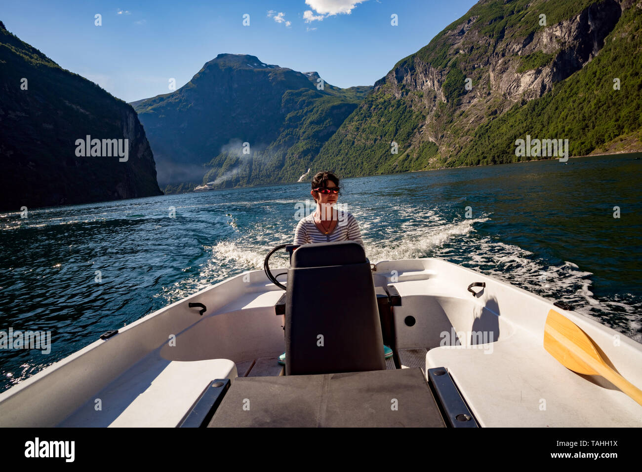 Donna alla guida di una barca a motore. Geiranger fjord, la bellissima natura della Norvegia.La vacanza estiva. Geiranger Fjord, un sito Patrimonio Mondiale dell'UNESCO. Foto Stock