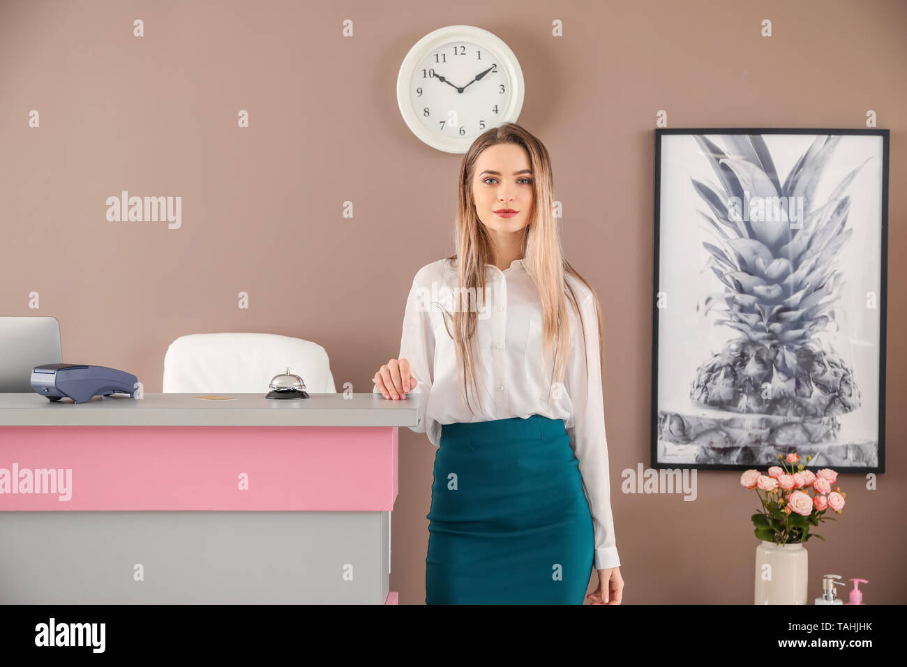 Receptionist femmina vicino alla scrivania in hotel Foto Stock