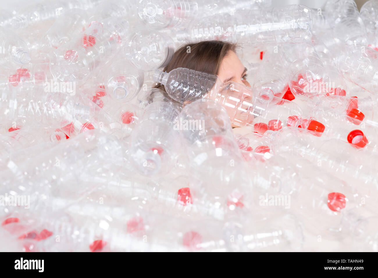 Disidratati malata è giacente in una pila di bottiglie di plastica. Il problema di inquinamento ambientale. Fermare la natura ambiente rifiuti il concetto di protezione Foto Stock