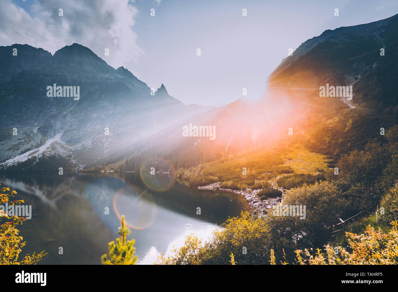 Parco nazionale dei Alti Tatra, Polonia. Famose Montagne Lago Morskie Oko mare o lago di occhio in serata d'estate. Bel Tramonto Sole raggi solari al di sopra di Tatra Foto Stock