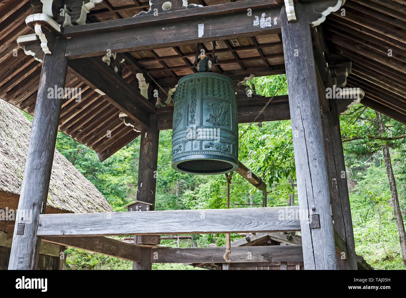 Asian Lady tirando la corda per suonare il campanello al Belfry presso il tempio Daishoin, l'isola di Miyajima, Giappone Foto Stock