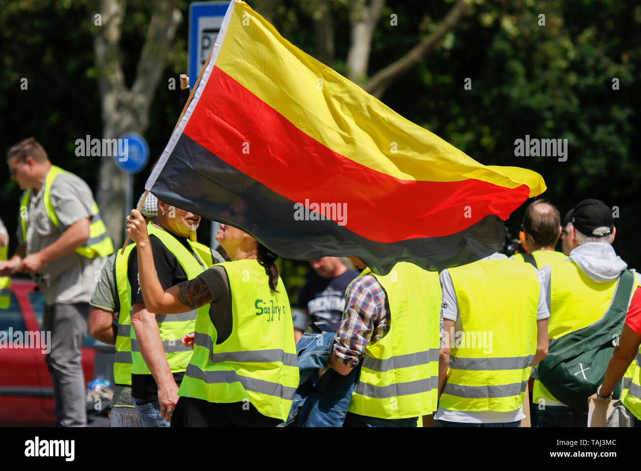 Wiesbaden, Germania. 25 Maggio, 2019. Un manifestante sventola una bandiera tedesca capovolto, un simbolo del Reichsburgerbewegung ("Reich movimento di cittadini"), che rifiutano il moderno Stato tedesco. Al di sotto di 100 Ala destra manifestanti hanno marciato con giubbotti di giallo attraverso Wiesbaden, per protestare contro il governo tedesco. Essi sono stati confrontati da piccolo ma forte protesta del contatore. Credito: Michael Debets/Pacific Press/Alamy Live News Foto Stock