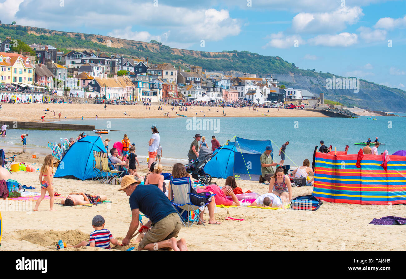 Lyme Regis, Dorset, Regno Unito. 25 maggio 2019. Meteo REGNO UNITO: folle di turisti e visitatori accorrono per la spiaggia di Lyme Regis a crogiolarvi al sole caldo come il resort costiero sfrigola su il giorno più caldo dell'anno finora. Il sabato è impostata in modo da essere il più soleggiato giorno di fine maggio weekend festivo. Credito: Celia McMahon/Alamy Live News. Foto Stock