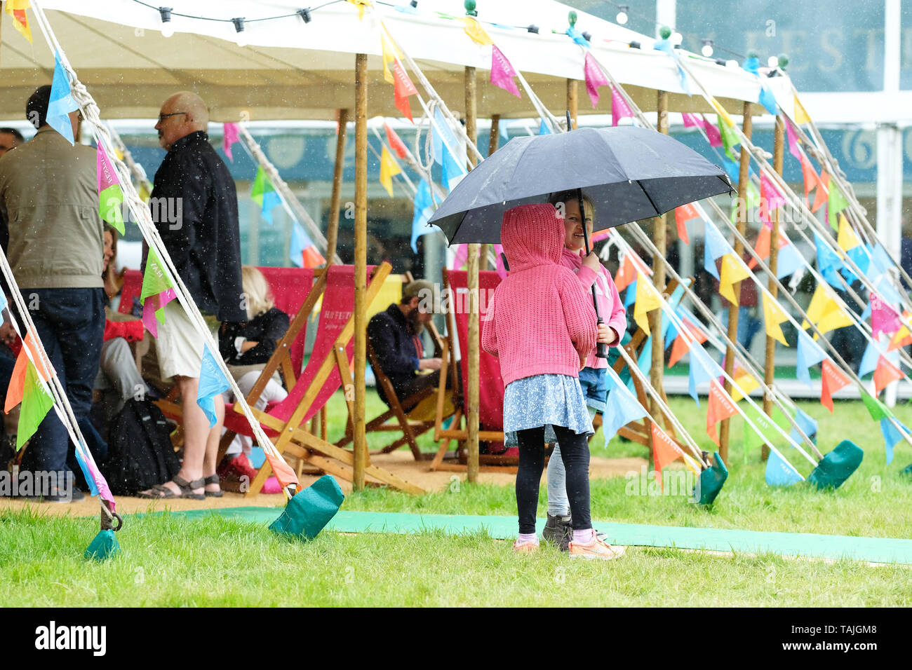 Festival di fieno, Hay on Wye, Powys, Wales, Regno Unito - Domenica 26 Maggio 2019 - Due giovani visitatori godere di una doccia a pioggia sotto il loro ombrello il giorno 4 di questo anni Hay Festival in un giorno di tempo misto - undici giorni del festival offre oltre 800 eventi. Foto Steven Maggio / Alamy Live News Foto Stock