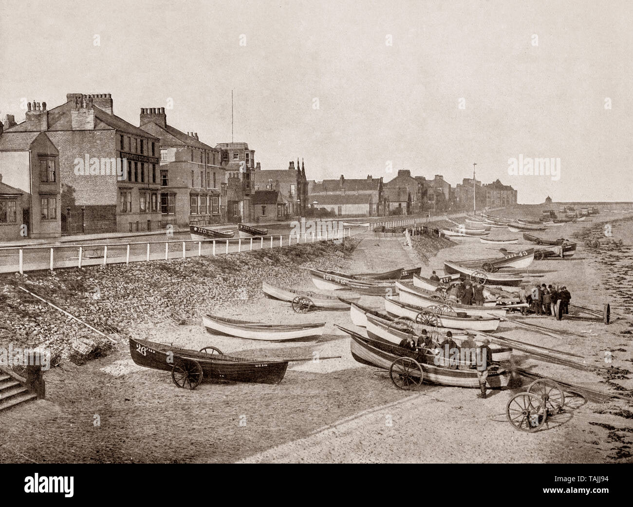 Un palazzo di fine ottocento vista della spiaggia con i pescatori e le loro barche a Redcar, una stazione balneare e città, parte del North Riding dello Yorkshire, Inghilterra. Foto Stock