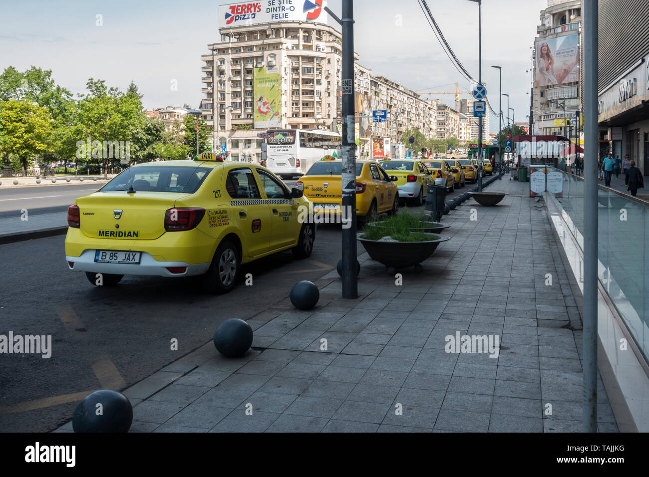 Fila di giallo taxi in taxi in Piața Unirii nel quartiere del centro storico di Bucarest, Romania Foto Stock