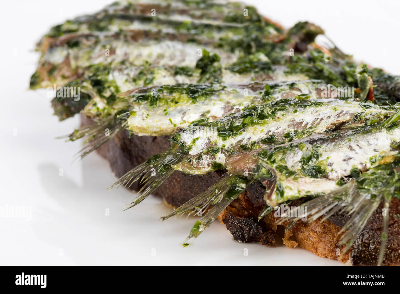 Acciughe su pane olio e prezzemolo Foto Stock