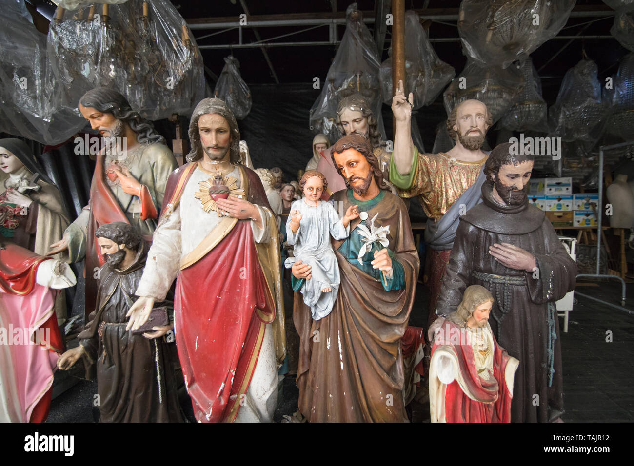 Scartato Cattolica Romana statuette cristiana memorizzati in un capannone Foto Stock