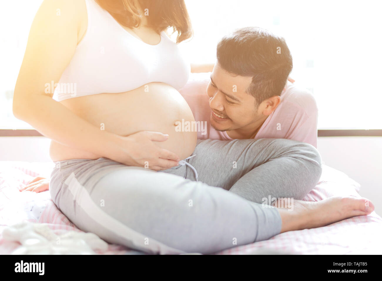 Asian donna incinta. Mamma e Bambino neonato. Festa della mamma e la giornata internazionale delle donne. Rilassarsi e svagarsi con mio marito. Foto Stock