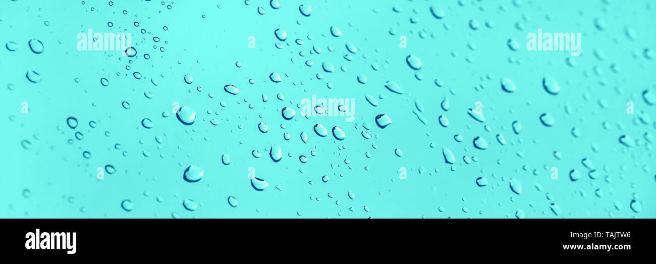 Gocce di acqua su vetro panoramico sfondo blu Foto Stock