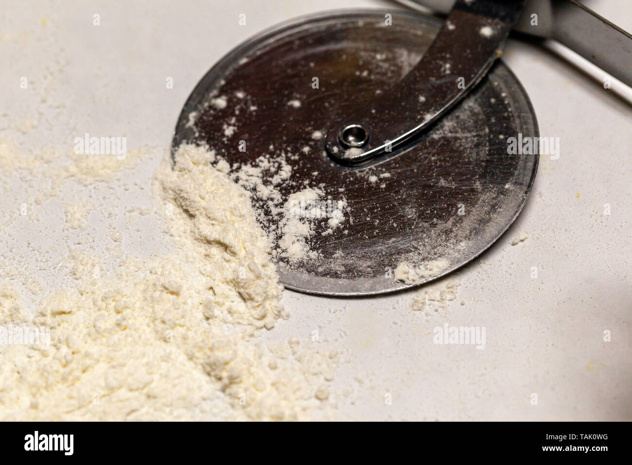 Un tagliapizza in appoggio in farina. Foto Stock
