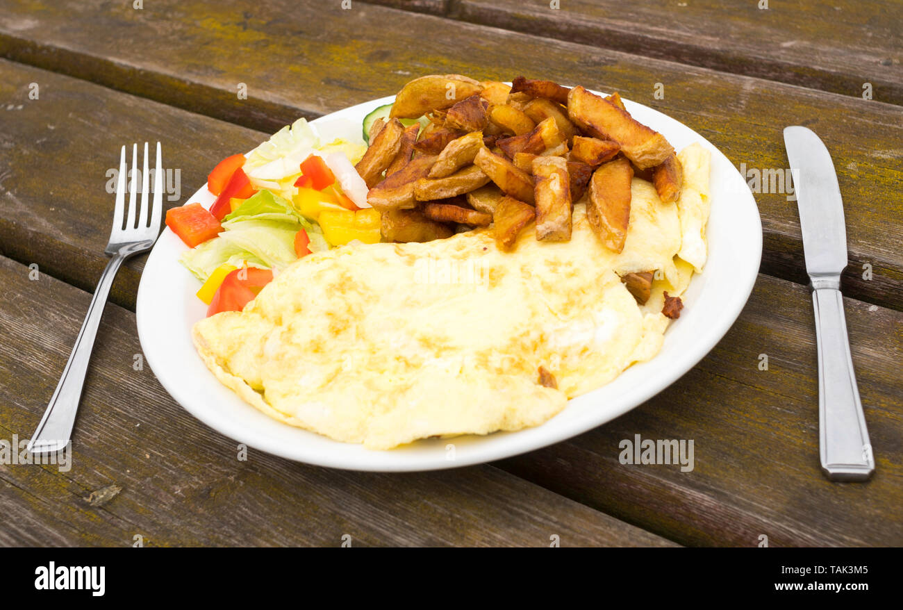 Piastra di frittata di funghi, patatine e insalata con coltello e forchetta su un tavolo di legno, Hownsgill sala da tè, Consett, England, Regno Unito Foto Stock