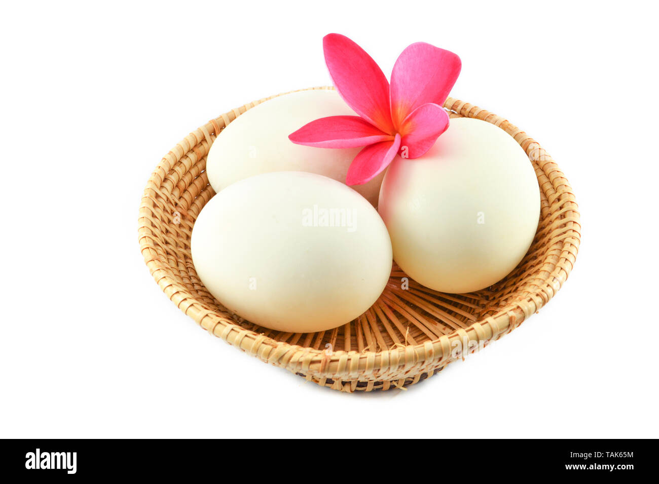 Bianco uova di anatra nel cestello e fiore rosa isolato su sfondo bianco / uovo salato Foto Stock