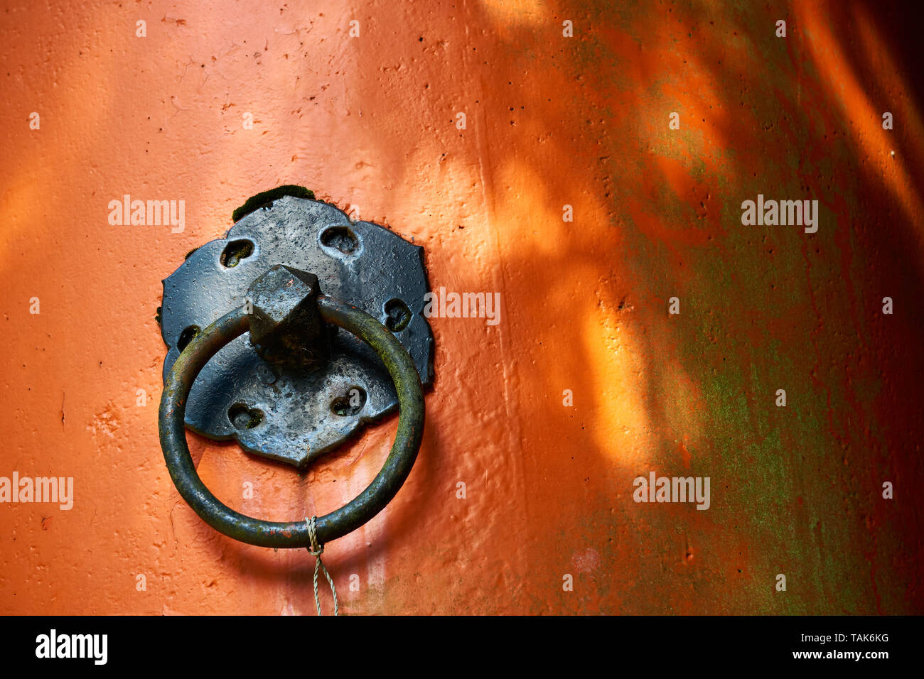 Un nero anello metallico è montato su un vermiglio di cemento dipinta colonna in corrispondenza di Kasuga Taisha Grand Santuario a Nara, Giappone. Foto Stock