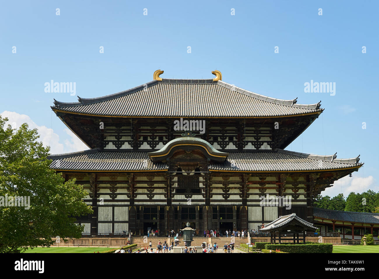Il Grande Buddha Hall (Daibutsu-den) al Tempio Todaiji a Nara, Giappone, con visitatori a piedi attorno al di fuori su di un giorno d'estate. Foto Stock