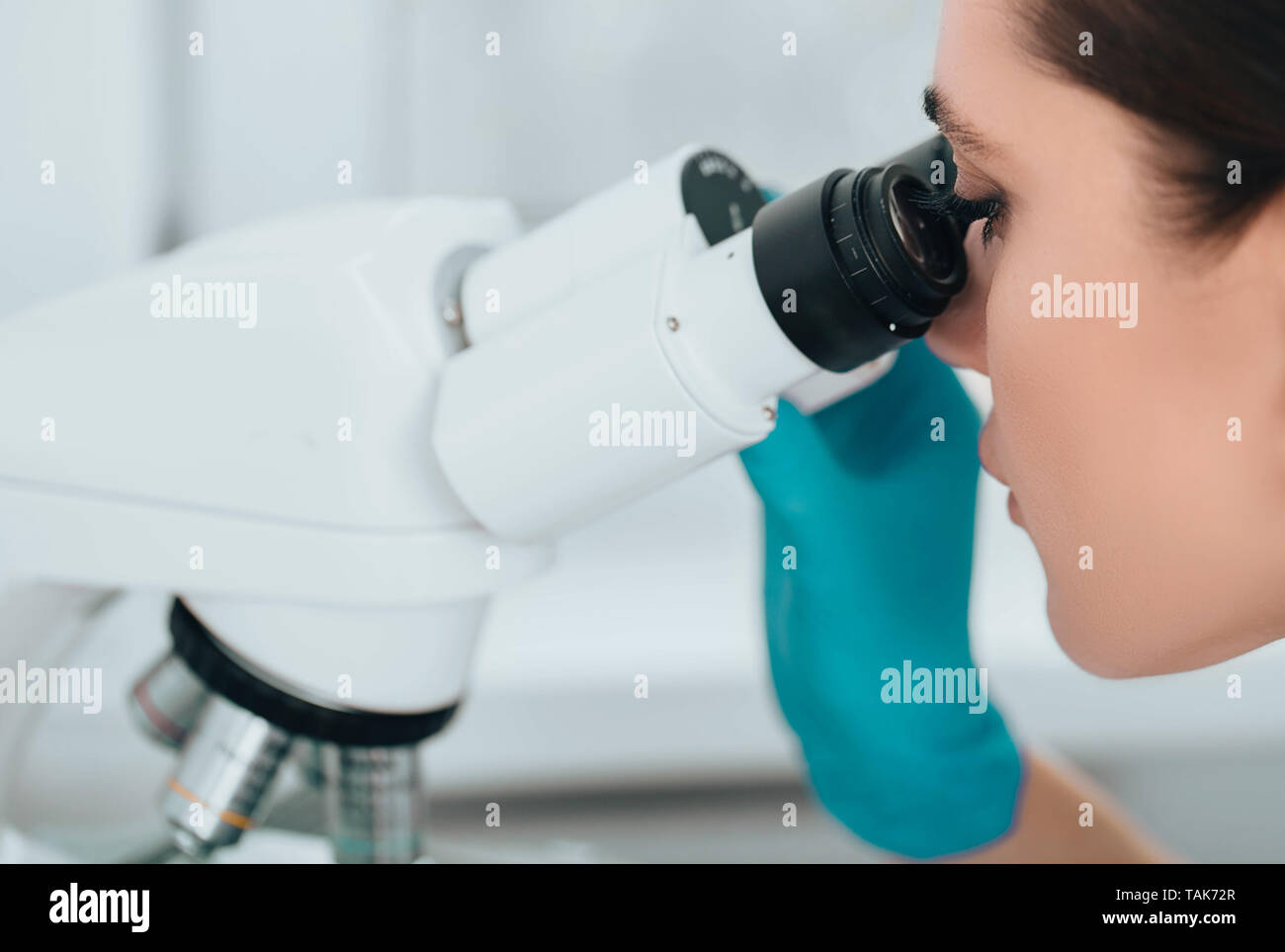 Tecnico utilizzando microscopio in laboratorio, close-up. Tecnico di laboratorio e il microscopio, macro Foto Stock