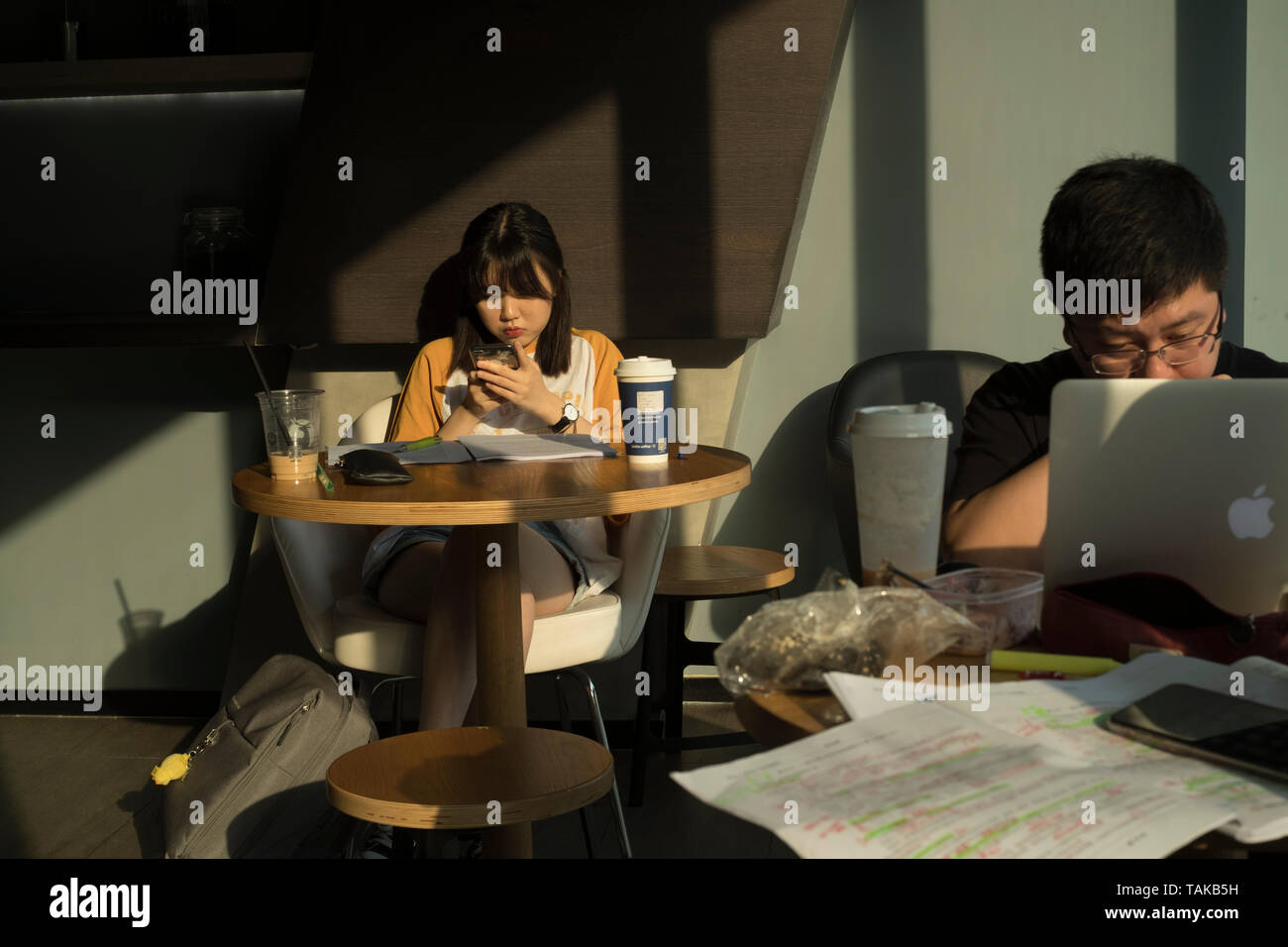 Giovane cinese e la donna utilizzando la tavoletta digitale in un coffee shop a Pechino in Cina. 25-Maggio-2019 Foto Stock
