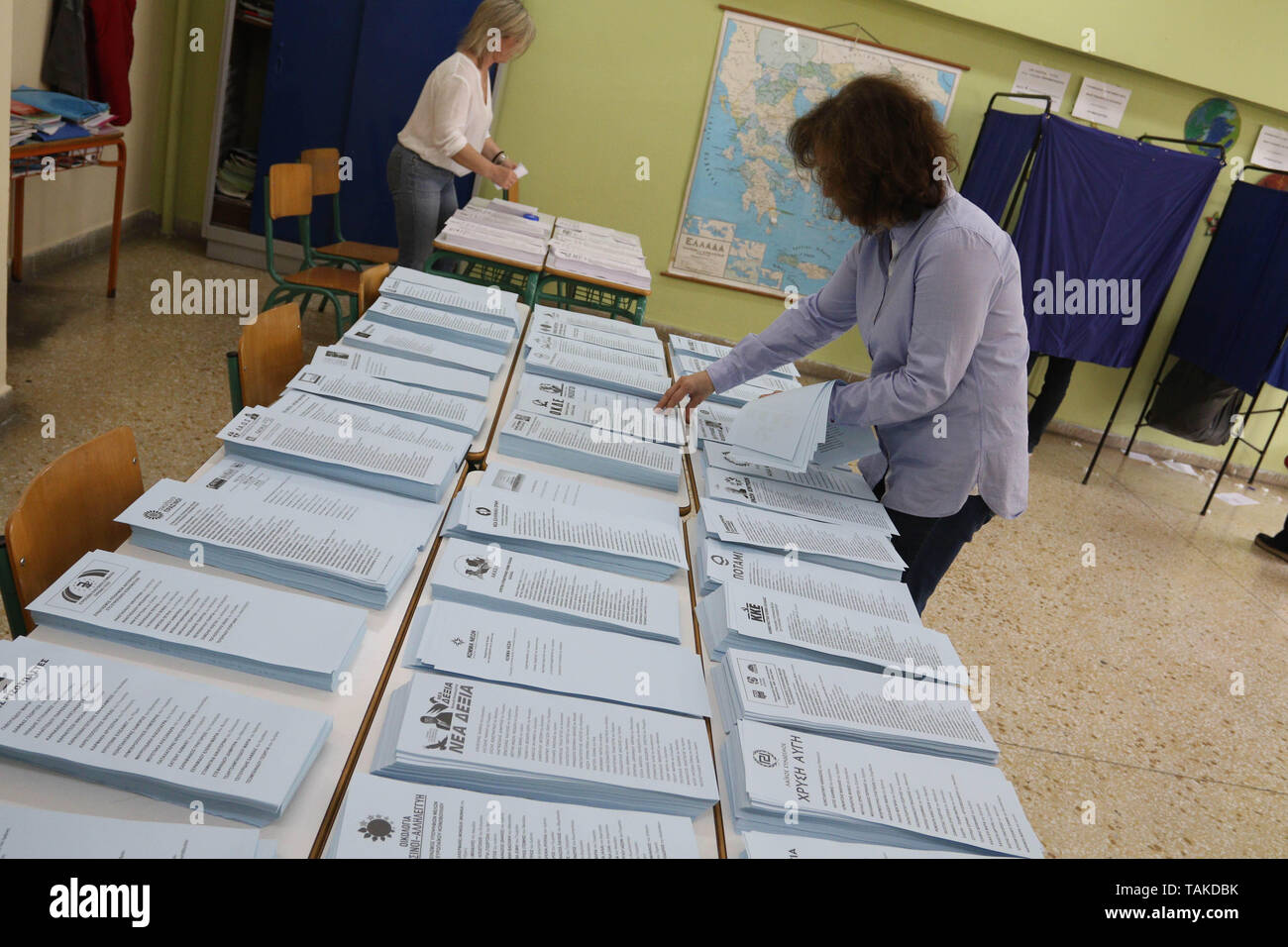 Una donna si vede di organizzare le schede in corrispondenza di una stazione di polling durante il primo round di greco e comunali elezioni regionali, in coincidenza con le elezioni del Parlamento Europeo a Patrasso. Foto Stock