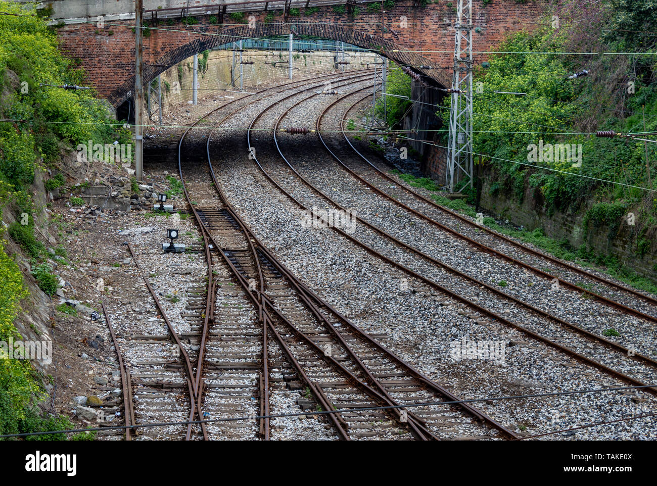 Dalla stazione ferroviaria, rotaie e ponte di pietra Foto Stock