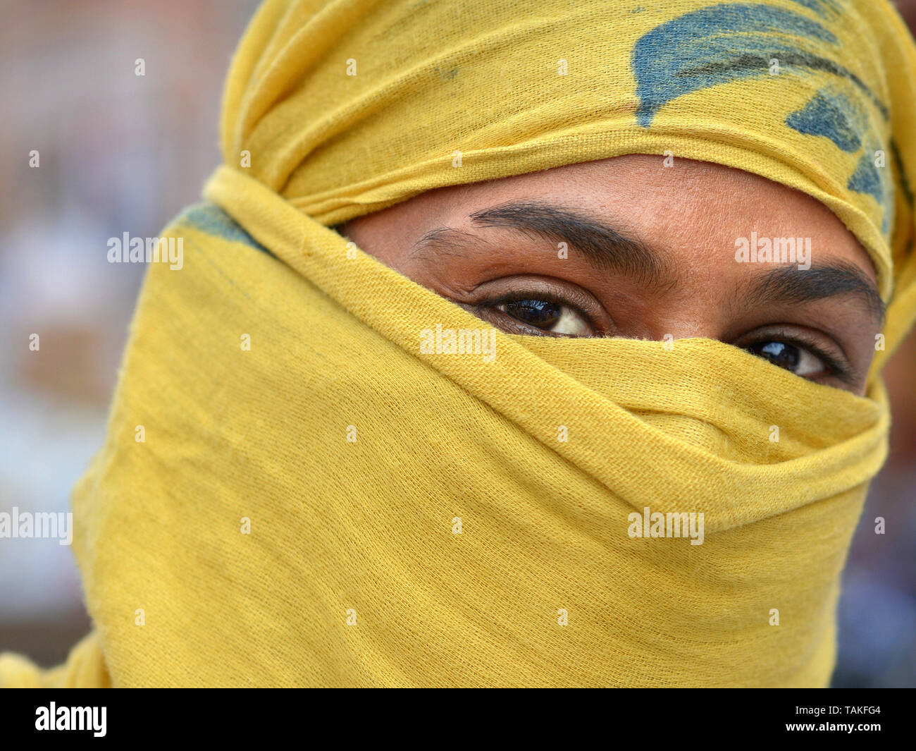 Rajasthani indiano scooter ragazza copre i suoi capelli e la parte inferiore del viso con un giallo secolare velo di polvere. Foto Stock