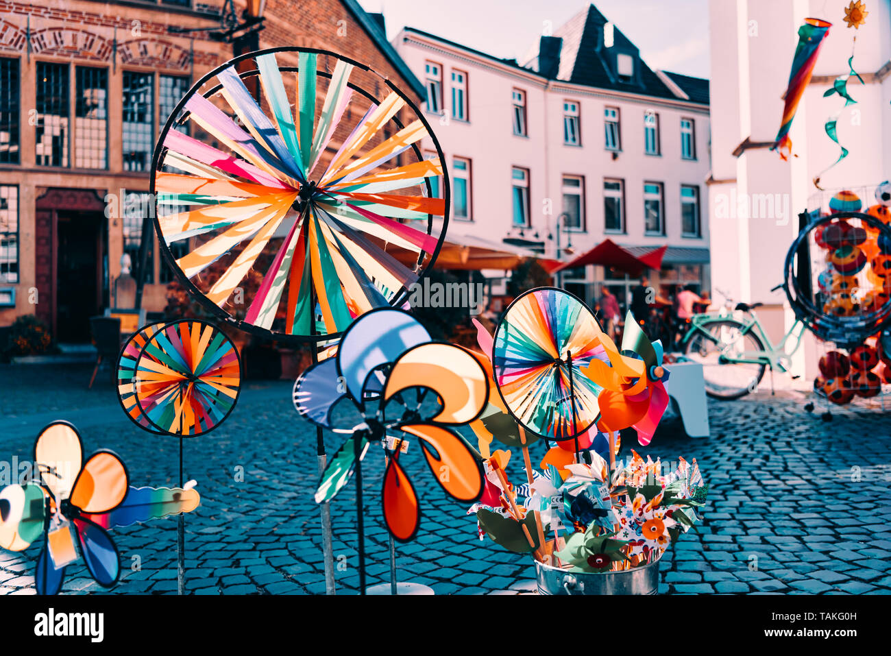 Colorato whirligigs contrastante con lo sfondo di una strada dello shopping di Xanten Foto Stock